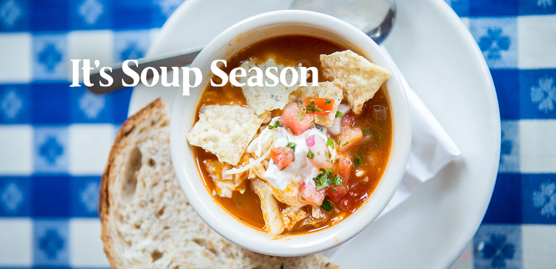 Bowl of Taco Soup with a slice of fresh bead on Merridee's blue gingham tablecloth